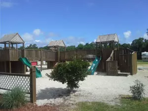 playground with wooden structures and white sand