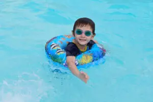 kid with a donut floatie in a pool