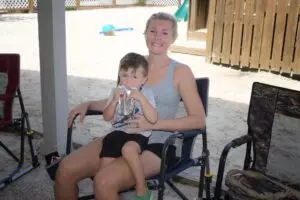 boy sitting on a the lap of woman drinking juice