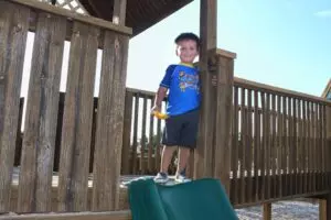 boy standing on a wooden deck