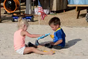 two kids playing on the sand